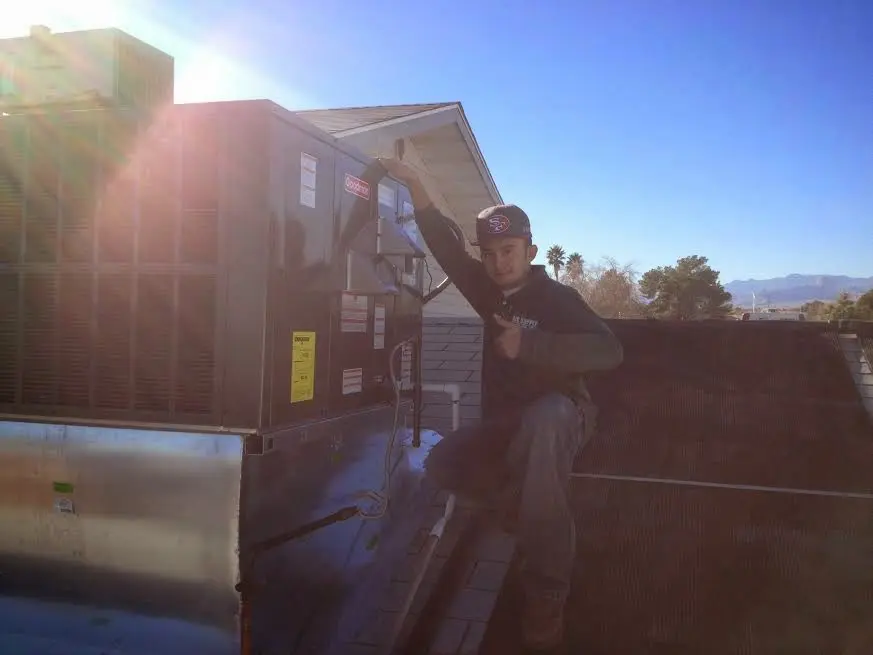 HVAC technician performing Heat Pump Repair on a rooftop unit in Merrydale